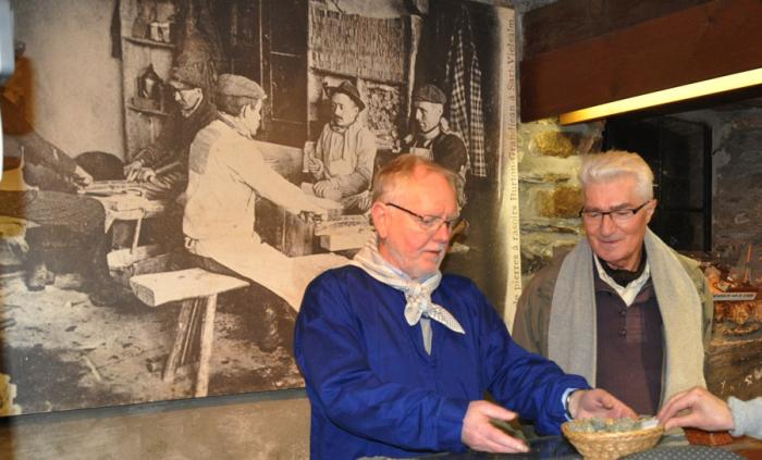 Pierre Clotuche et Joseph Clesse avec, à l’arrière-plan, la photo d’un ancien atelier de façonnage du coticule…